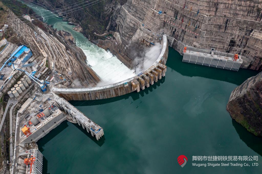 10月24日下午，白鶴灘水電站右岸地下廠房最后一倉封頂混凝土澆筑完成，標志著世界在建最大水電站地下廠房全線封頂。在該工程建設中，河鋼集團舞鋼公司累計生產供應Q500、Q345C/B、SX780等數個新品種鋼板4500噸，主要用于水電站水輪機座環、發電機頂蓋、控制環、壓力鋼管制造，大大加速了大型發電機組用鋼國產化進程。    據介紹，白鶴灘水電站位于四川省涼山州和云南省昭通市交界處，是世界在建規模最大的水電工程，裝機總容量1600萬千瓦，其左右岸地下廠房內分別布置8臺具有完全自主知識產權的單機容量達100萬千瓦的水輪發電機組，單機容量位居世界第一。10月24日下午，白鶴灘水電站成功蓄水至825米高程，首次達到正常水位，大壩將接受高水位全面檢驗。    該工程的規模天然決定了其施工難度極高，復雜的地形地質條件和技術指標等因素也給施工帶來了巨大挑戰。因此在電站建設材料及關鍵部位用鋼的選擇上，客戶慎之又慎，對焊接性能、韌性、強度等均有著極為嚴苛的技術要求。舞鋼公司憑借強大的質量品牌優勢和雄厚的技術實力成功中標——數百噸“舞鋼牌”高技術含量的大厚度高級別水電鋼板用于制造世界單機容量最大的巨型水輪發電機組的座環。    隨后，舞鋼公司為白鶴灘水電站定制研發265mm厚的SXQ500D-Z35鋼板，并進一步制作加工件。公司科技部高強鋼研究所針對該鋼的生產重點和難點，提前制定措施，并在冶煉、制坯等關鍵環節派人進行跟蹤、協調。在科技、設備、生產人員的共同努力下，該批鋼板最終順利生產完畢。鋼板及試樣經公司、客戶和第三方檢驗機構檢驗合格后，在三和盛機建公司完成切割深加工。    交付客戶后，該鋼憑著焊接性能好、力學結構良好、低溫沖擊韌性強等優點，承受住了巨大的水壓力和沖擊負荷，再次贏得設備制造方的高度評價。（舞鋼市委宣傳部 楊德坤 張培軍）